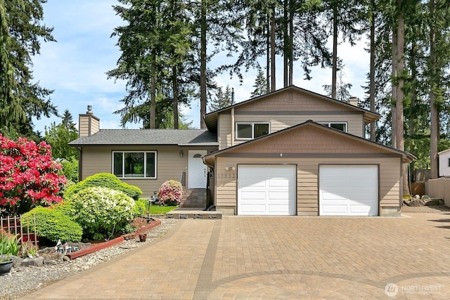 13832 146th Pl SE, Renton, WA 98059 - tri-level home featuring a chimney, a garage, and decorative driveway