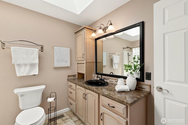 13832 146th Pl SE, Renton, WA 98059 - bathroom with a skylight, toilet, vanity, and baseboards