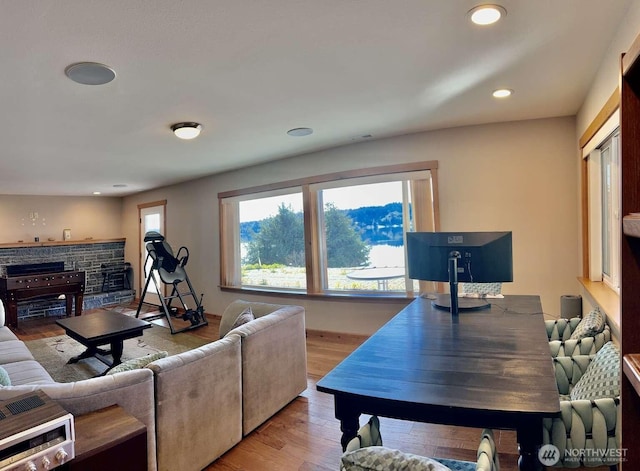 living room featuring a fireplace, wood finished floors, recessed lighting, and baseboards