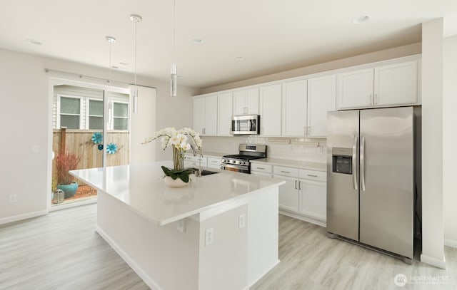 6146 Windlass Ave SE, Port Orchard, WA 98367 - kitchen with stainless steel appliances, a sink, light wood-style flooring, tasteful backsplash, and recessed lighting