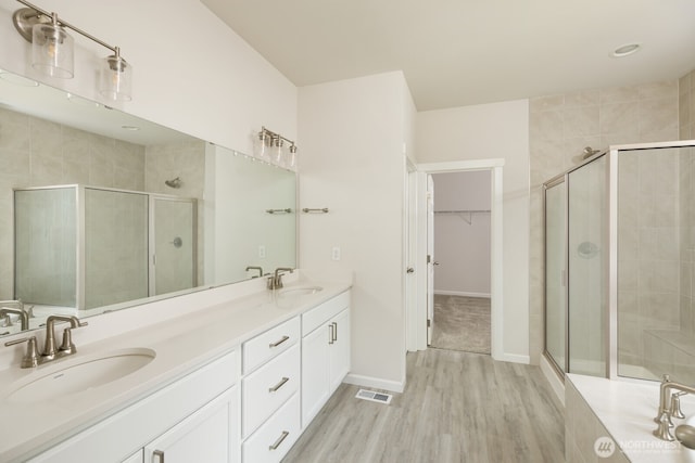 6146 Windlass Ave SE, Port Orchard, WA 98367 - bathroom with a shower stall, wood finished floors, double vanity, and a spacious closet