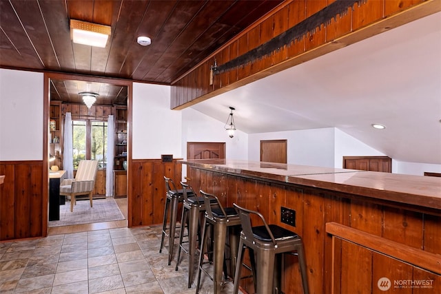 8820 E State Route 106, Union, WA 98592 - kitchen with wood walls, a wainscoted wall, wooden ceiling, light stone finish flooring, and brown cabinetry