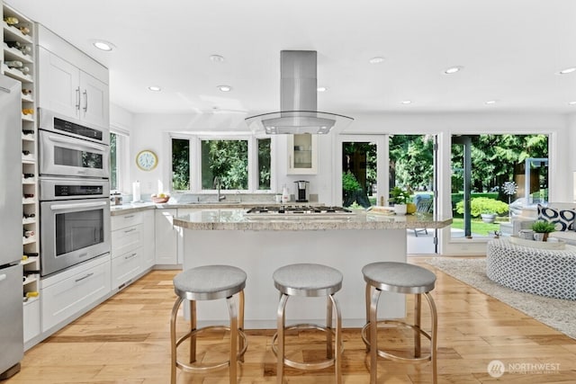 21010 NE 33rd Pl, Sammamish, WA 98074 - kitchen with island exhaust hood, white gas cooktop, a sink, recessed lighting, and a kitchen breakfast bar