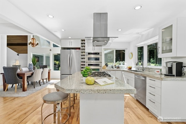 21010 NE 33rd Pl, Sammamish, WA 98074 - kitchen with stainless steel appliances, island range hood, a sink, a breakfast bar, and light wood-style floors