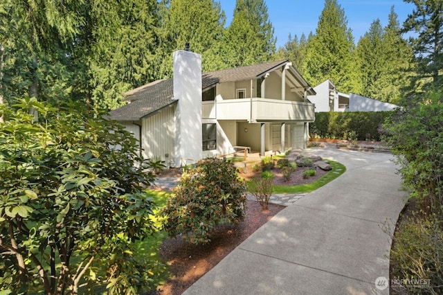 21010 NE 33rd Pl, Sammamish, WA 98074 - view of front facade with a balcony, concrete driveway, a chimney, and a shingled roof