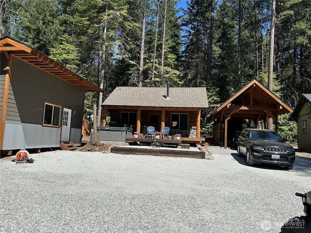 22415 Stirrup Rd, Leavenworth, WA 98826 - view of front of house with gravel driveway, an outdoor structure, and a carport