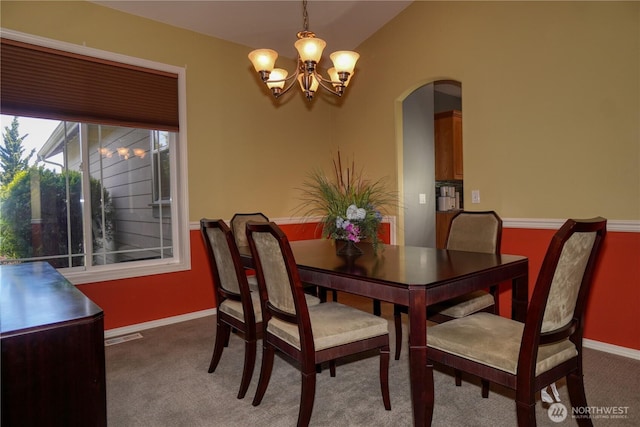 dining area with a chandelier, arched walkways, baseboards, carpet, and lofted ceiling