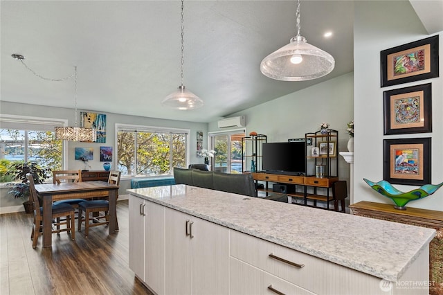 kitchen featuring a wall mounted AC, dark wood-style floors, plenty of natural light, and hanging light fixtures