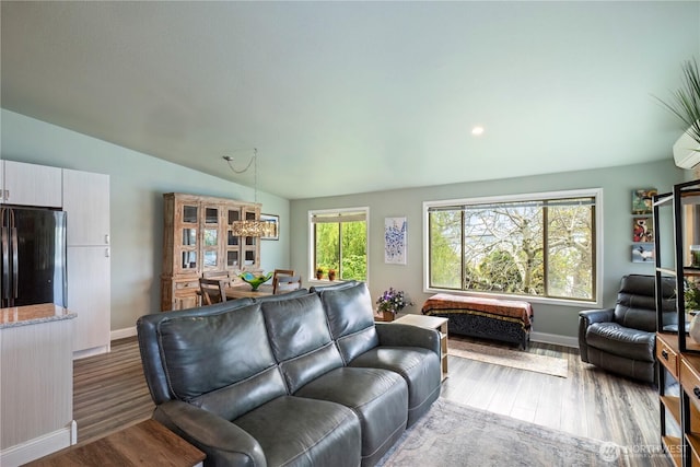 living area featuring wood finished floors, baseboards, lofted ceiling, and recessed lighting