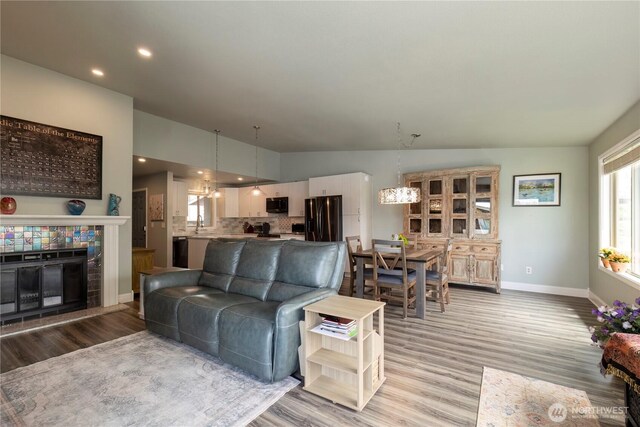 living area featuring light wood finished floors, baseboards, and recessed lighting