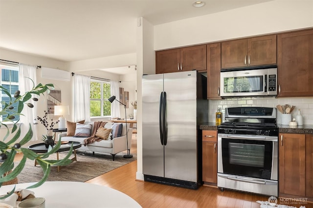 1748 25th Walk NE, Issaquah, WA 98029 - kitchen with appliances with stainless steel finishes, dark countertops, decorative backsplash, and light wood-type flooring