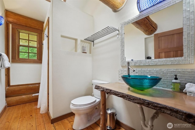 1465 Magnolia Ln, Camano Island, WA 98282 - bathroom with a sink, baseboards, decorative backsplash, and hardwood / wood-style flooring
