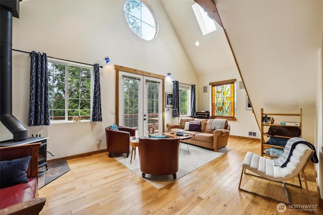 1465 Magnolia Ln, Camano Island, WA 98282 - living room with a wood stove, high vaulted ceiling, french doors, light wood-style floors, and a skylight