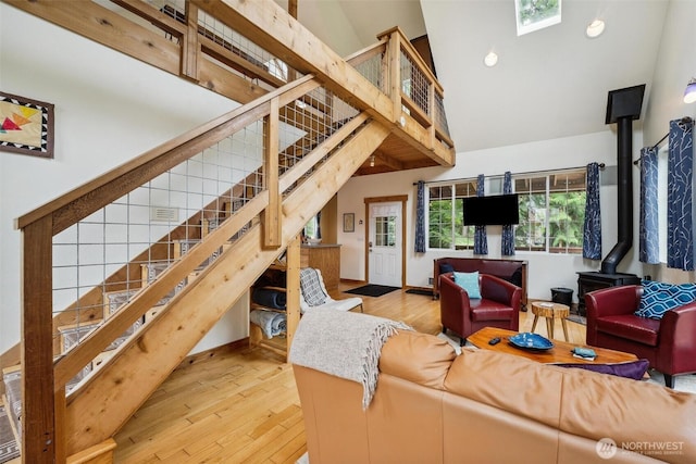 1465 Magnolia Ln, Camano Island, WA 98282 - living room featuring a wood stove, stairs, high vaulted ceiling, light wood finished floors, and a skylight