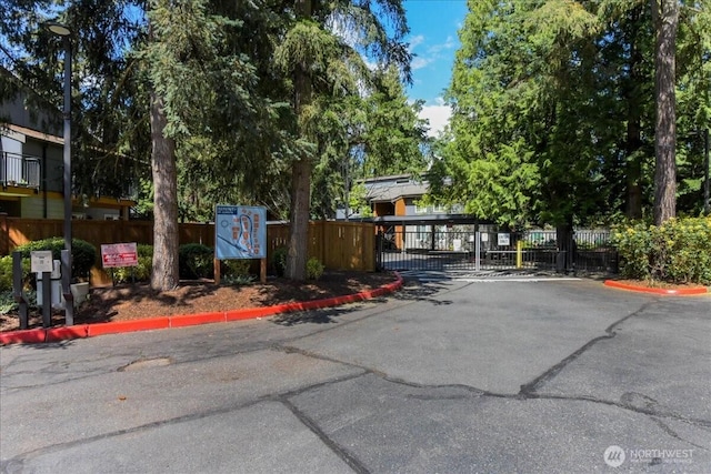 10826 NE 148th Ln Unit H201, Bothell, WA 98011 - view of asphalt road with curbs, a gate, and a gated entry