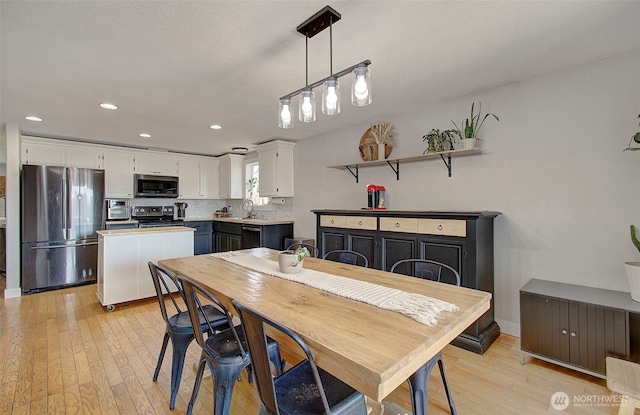dining space with light wood-type flooring and recessed lighting
