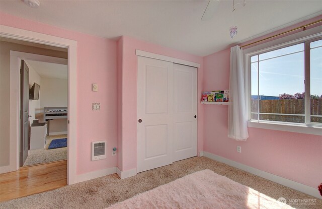 carpeted bedroom with baseboards and a closet