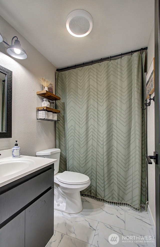 full bath featuring marble finish flooring, toilet, vanity, and a shower with curtain