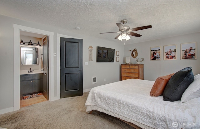 bedroom with light carpet, a sink, baseboards, ceiling fan, and a textured ceiling