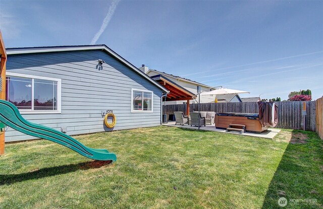 rear view of house featuring a hot tub and a patio area
