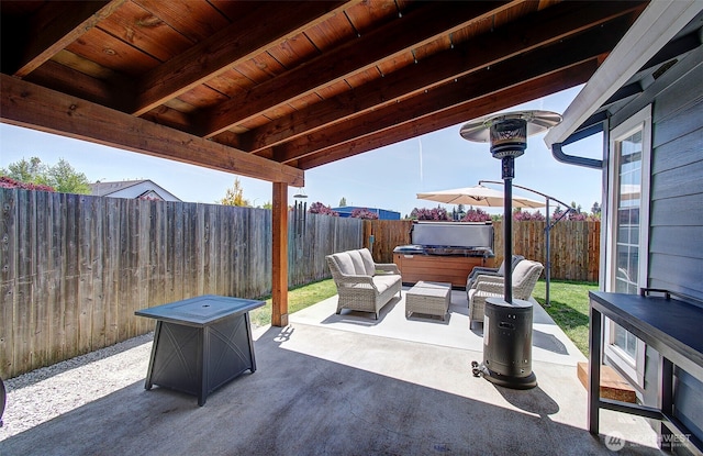 view of patio featuring a hot tub, a fenced backyard, and an outdoor living space