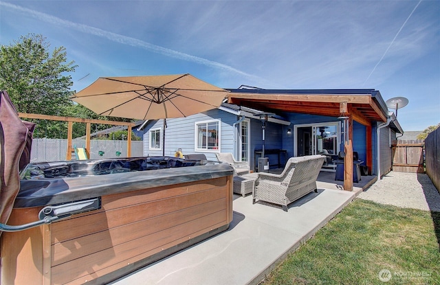 view of patio / terrace with a hot tub, a fenced backyard, and an outdoor living space