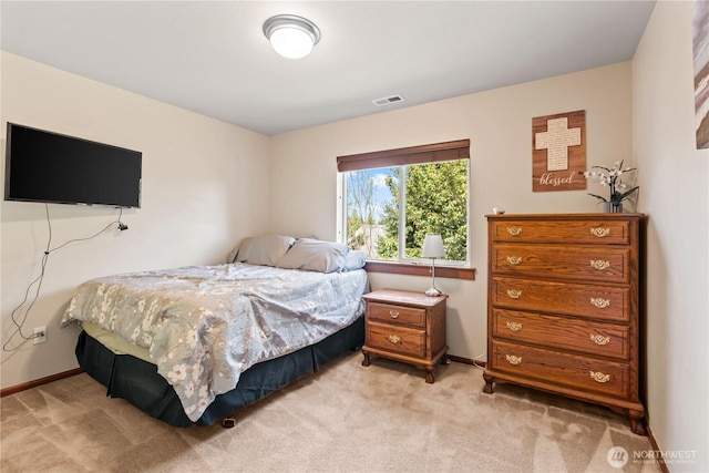 bedroom featuring light carpet and baseboards