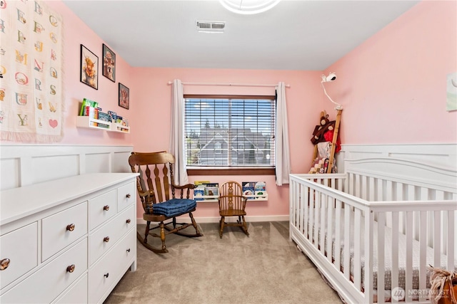 bedroom featuring light colored carpet and wainscoting