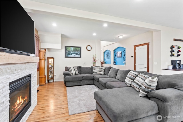 living area with a fireplace, light wood-style flooring, recessed lighting, and baseboards