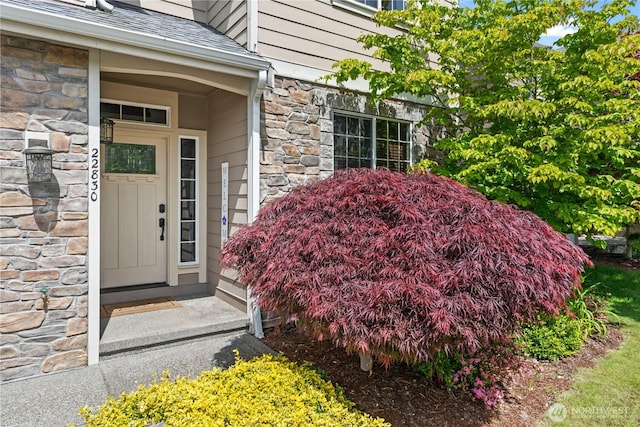 property entrance with stone siding