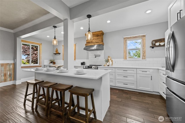 256 S C St, Buckley, WA 98321 - kitchen featuring stainless steel appliances, extractor fan, a kitchen breakfast bar, crown molding, and white cabinetry
