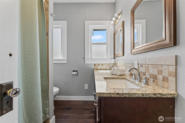 256 S C St, Buckley, WA 98321 - bathroom featuring wood finished floors, backsplash, toilet, double vanity, and baseboards