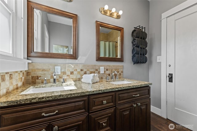 256 S C St, Buckley, WA 98321 - bathroom featuring double vanity, tasteful backsplash, wood finished floors, and baseboards