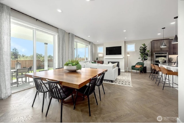 dining room featuring a fireplace, baseboards, and recessed lighting