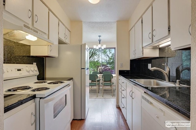 12525 NE 145th Pl Unit F105, Kirkland, WA 98034 - kitchen featuring white appliances, a sink, a chandelier, under cabinet range hood, and wood finished floors