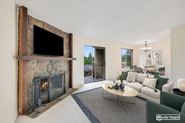 12525 NE 145th Pl Unit F105, Kirkland, WA 98034 - living area featuring a chandelier, a stone fireplace, carpet flooring, and a textured ceiling