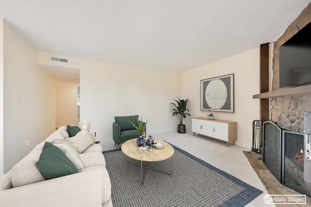 12525 NE 145th Pl Unit F105, Kirkland, WA 98034 - living room featuring carpet floors, a stone fireplace, and a textured ceiling