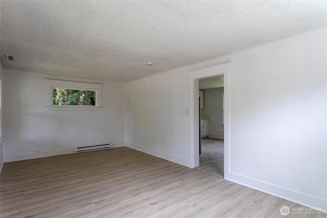 6835 S I St, Tacoma, WA 98408 - empty room featuring a baseboard heating unit, a textured ceiling, wood finished floors, and baseboards