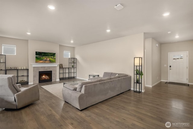 living room featuring wood finished floors, recessed lighting, baseboards, a tile fireplace, and plenty of natural light
