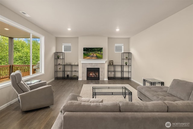 living room featuring wood finished floors, baseboards, a tile fireplace, and recessed lighting