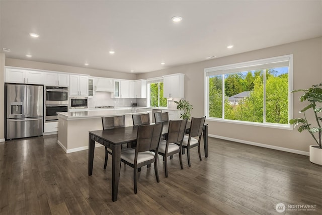 dining area featuring baseboards, dark wood finished floors, and recessed lighting
