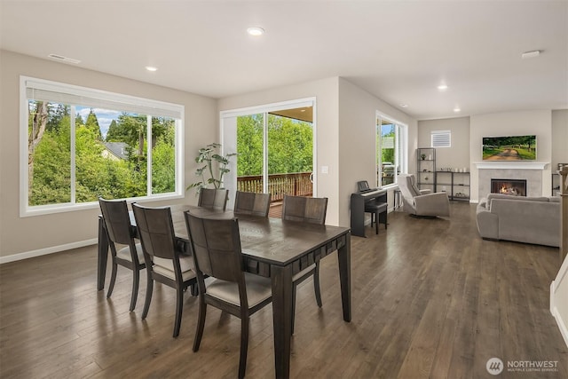 dining area featuring dark wood-style floors, baseboards, recessed lighting, and a fireplace