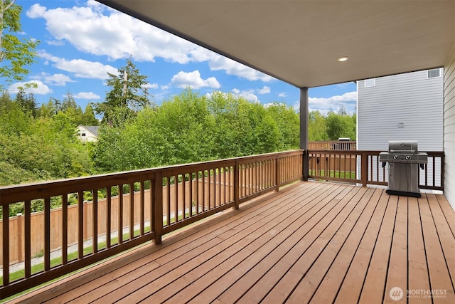 deck featuring a grill and view of wooded area