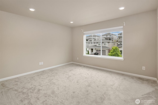carpeted empty room featuring baseboards and recessed lighting