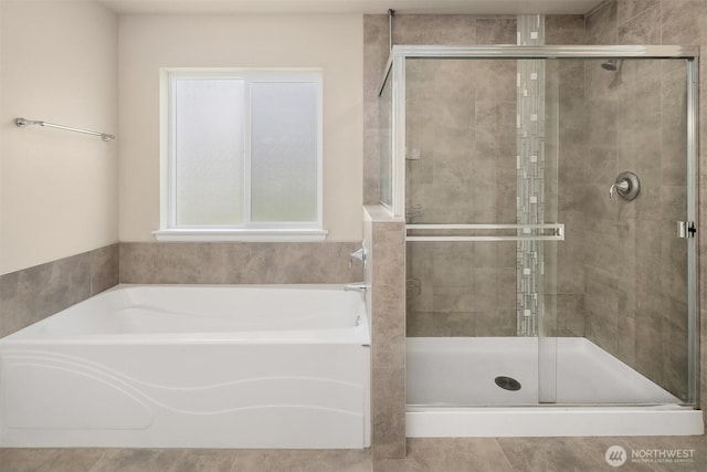 bathroom with a shower stall and a garden tub