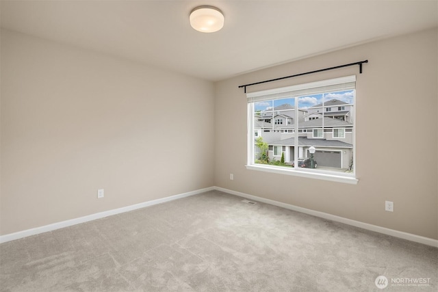 empty room featuring baseboards and carpet