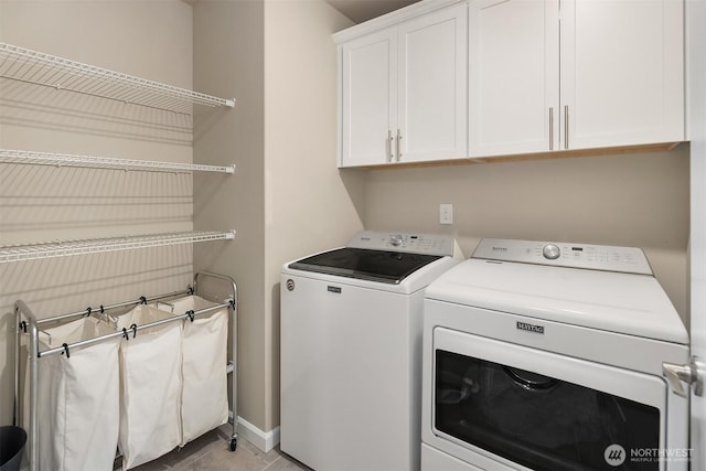 laundry room featuring washer and dryer, cabinet space, and baseboards
