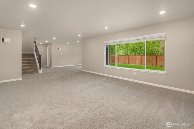 carpeted empty room with stairway, baseboards, and recessed lighting
