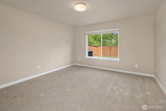 carpeted empty room with baseboards
