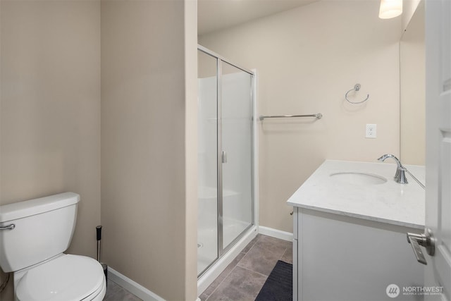 full bath featuring a stall shower, vanity, toilet, baseboards, and tile patterned floors